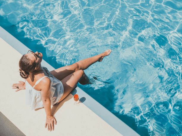 fashionable-woman-sitting-by-the-pool-on-the-empty-deck